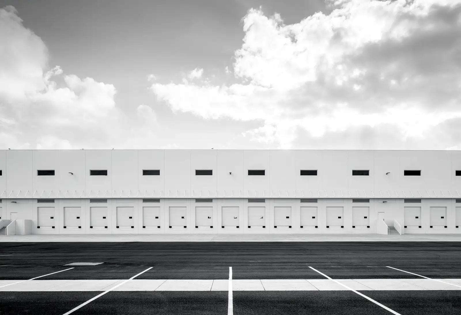 A modern distribution warehouse with a row of loading-dock doors